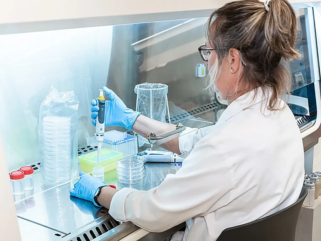 Fotografía laboratorio farmacéutico técnico pipeteando cabina flujo laminar Barcelona
