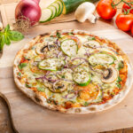 Fotografía de comida para restaurante en Sant Cugat del Vallès: Restaurant Xarlot Fotografía gastronómica de pizza vegetariana con calabacín, champiñones y cebolla roja para restaurante Xarlot.