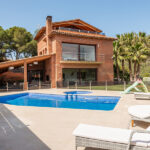 Villa de lujo de dos plantas con piscina exterior, palmeras y vistas a la montaña — fotografía inmobiliaria Barcelona